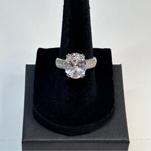 18k white gold-plated ring featuring a large white oval CZ stone and pave band